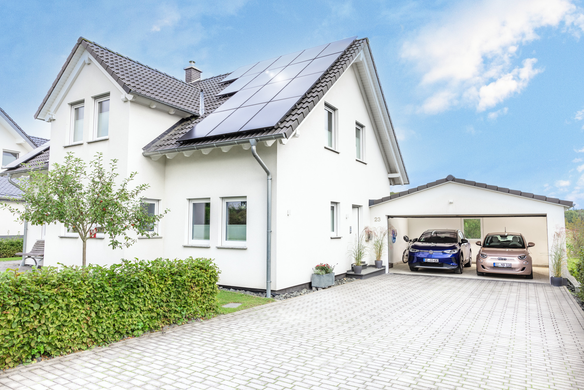 Haus mit PV-Anlage auf dem Dach und Wallbox in der Garage