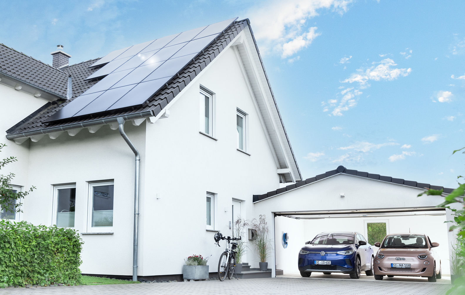 Haus mit Solaranlage auf dem Dach und Wallbox in der Garage