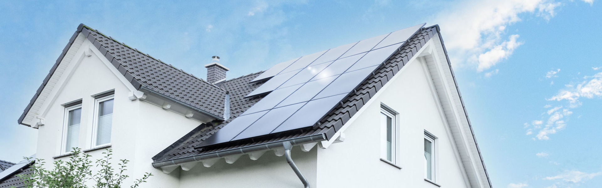Haus mit Solaranlage auf dem Dach und Wallbox in der Garage